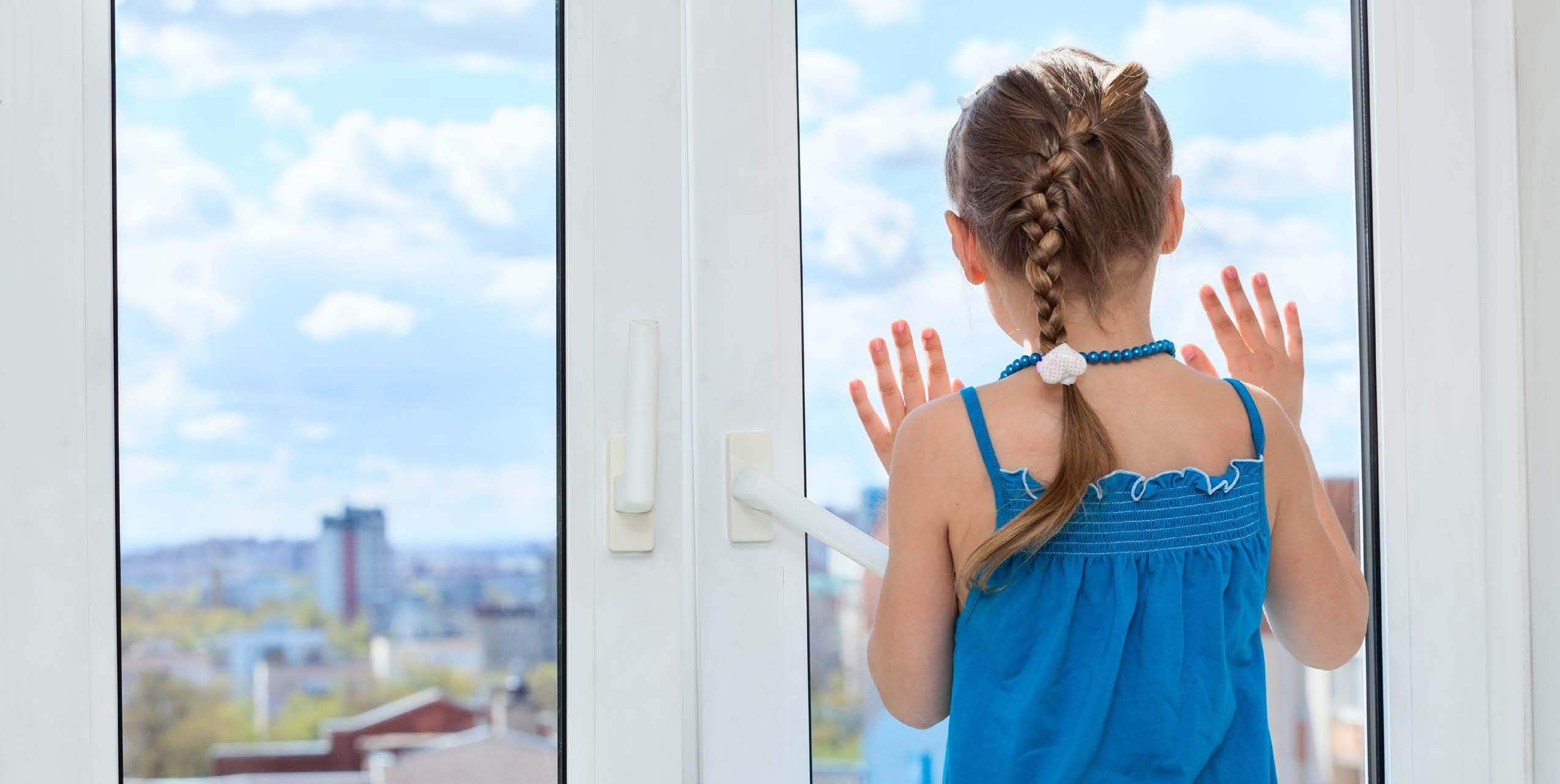 small child looking out a door with a window